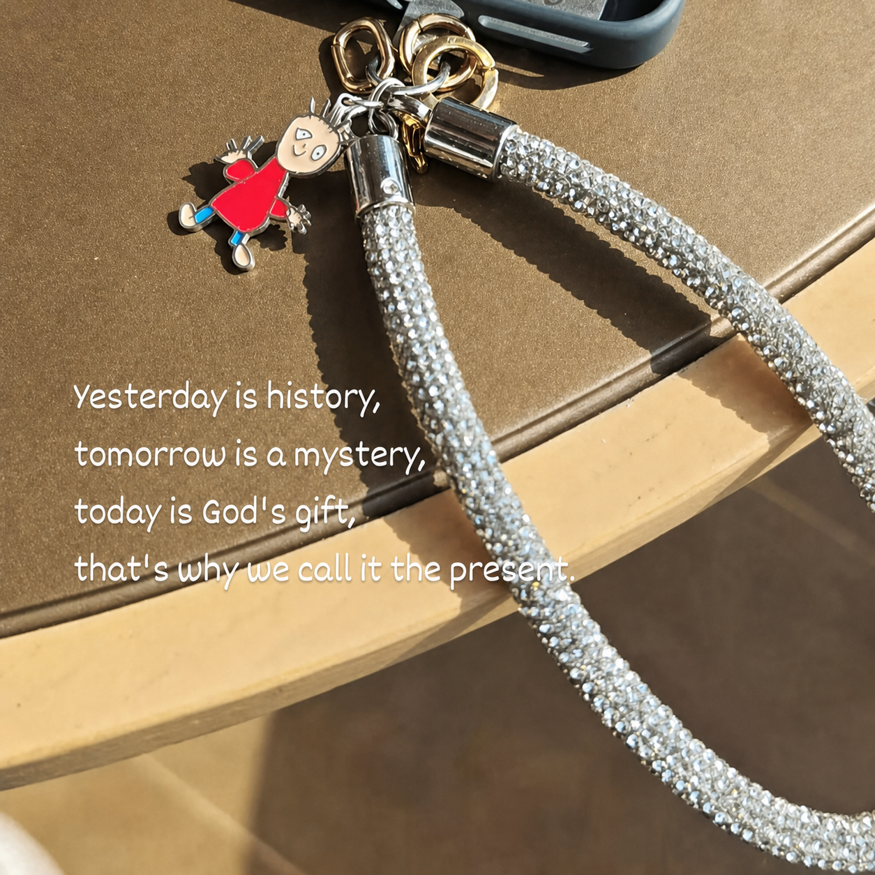 Held Dear pendant on a phone strap